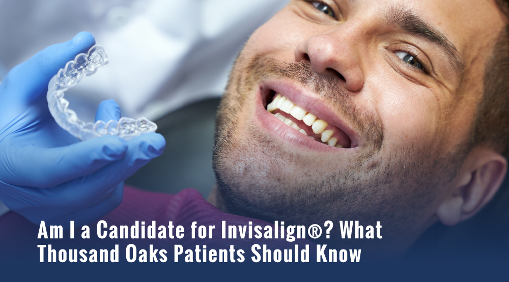 Smiling man in a dental chair as a gloved hand holds a clear Invisalign aligner tray